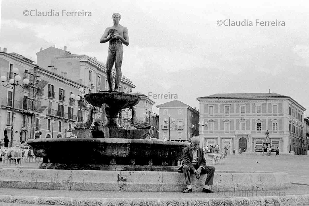 Idoso sentado ao lado da Fontana Vecchia